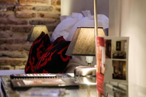 a table with two remote controls and a lamp on it at Hôtel des Arts in Toulouse