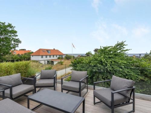 a group of chairs and tables on a deck at Holiday Home Ebke - 70m from the sea in Sealand by Interhome in Gilleleje