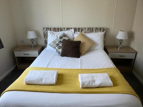 a large white bed with two pillows on it at Tulip Lodge with Hot Tub in Malton