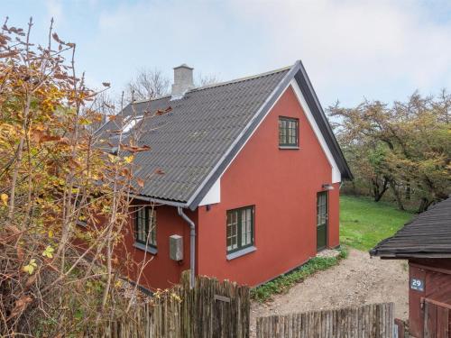 ein rotes Haus mit schwarzem Dach in der Unterkunft Holiday Home Tabetha - 25m from the sea in Sealand by Interhome in Tisvildeleje