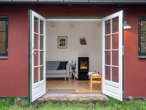 an open door into a living room with a couch at Holiday Home Tabetha - 25m from the sea by Interhome in Tisvildeleje