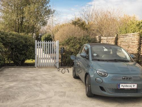 a small blue car parked next to a white fence at Holiday Home Cedomir - 625m from the sea in Sealand by Interhome in Hornbæk