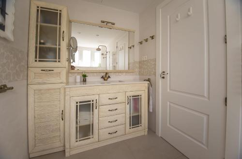 a bathroom with a sink and a mirror and a door at Casa adosada con piscina comunitaria Solo familias no grupos de jovenes in Salou