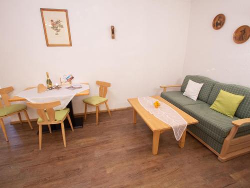 een woonkamer met een bank en een tafel bij Apartment Koa Sünd by Interhome in Pfarrwerfen