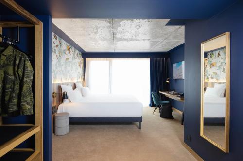 a bedroom with a white bed and a window at KOPSTER Hotel Residence Paris Ouest Colombes in Colombes