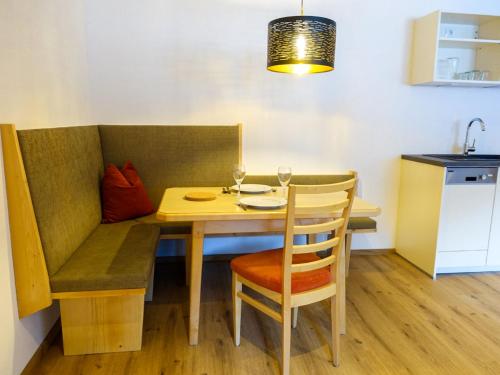 una mesa de comedor y sillas con copas de vino. en Apartment Freiheit-La by Interhome, en Schnann