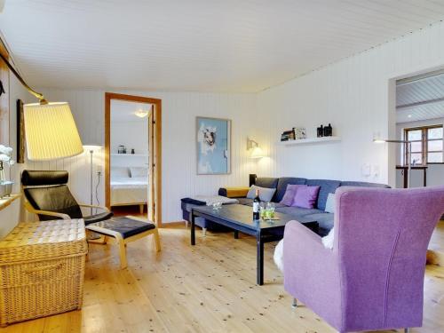 ein Wohnzimmer mit einem lila Sofa und einem Tisch in der Unterkunft Holiday Home Ilena - 16-3km from the sea in Sealand by Interhome in Borup