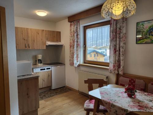 una pequeña cocina con mesa y ventana en Apartment Apart Maashof-3 by Interhome en Galtür