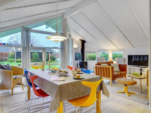 a living room with a table and colorful chairs at Holiday Home Eivor - 500m from the sea in Sealand by Interhome in Hornbæk