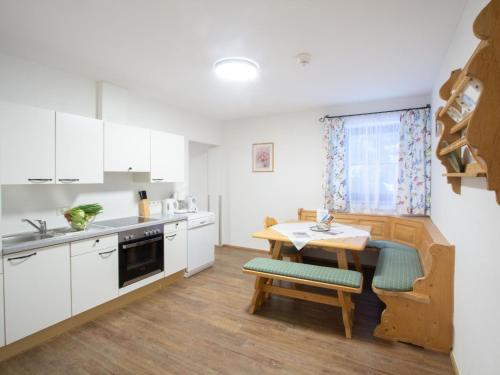 een keuken met witte kasten en een houten tafel bij Apartment Sonnenblick by Interhome in Pfarrwerfen