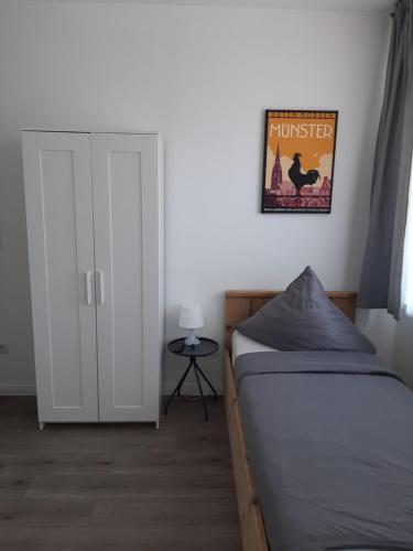 a bedroom with a bed and a poster on the wall at Pension Asche in Münster