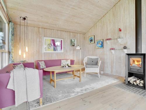 a living room with a purple couch and a table at Holiday Home Rixa - 525m from the sea in Sealand by Interhome in Slagelse