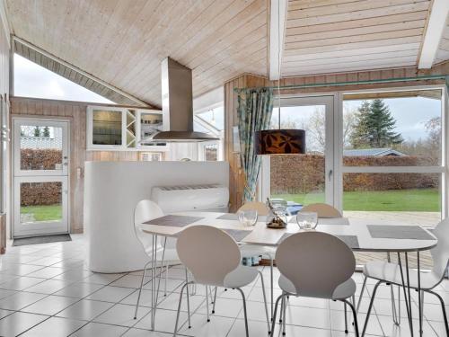 a kitchen and dining room with a table and chairs at Holiday Home Rixa - 525m from the sea in Sealand by Interhome in Slagelse