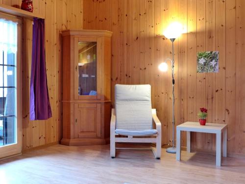 a room with a chair and a lamp and a table at Apartment Elsighornblick by Interhome in Kandergrund