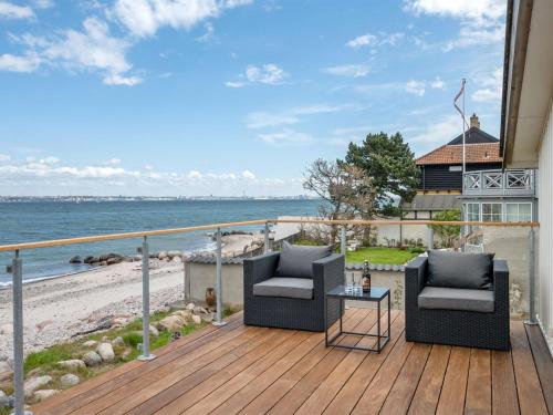 a balcony with two chairs and a table on the beach at Holiday Home Elsabeth - 20m from the sea in Sealand by Interhome in Helsingør