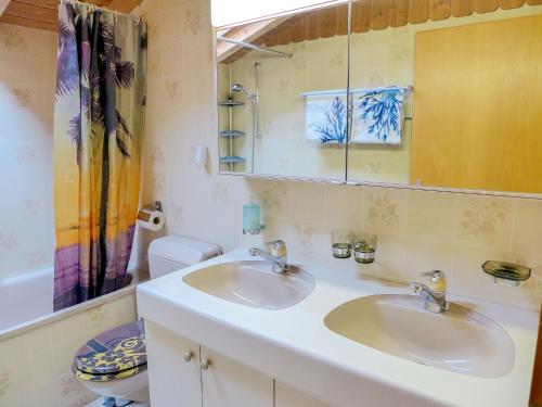 a bathroom with two sinks and a mirror and a toilet at Apartment Elsighornblick by Interhome in Kandergrund