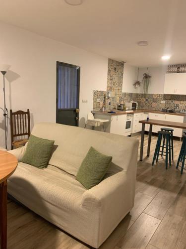sala de estar con sofá y cocina en Vivienda rural Vega del Guadalquivir, en Villacarrillo