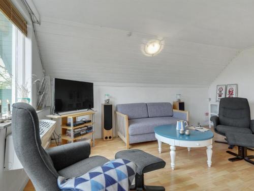 un soggiorno con divano, sedie e TV di Holiday Home Marita - 225m from the sea in Sealand by Interhome a Korsør