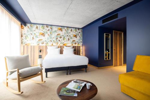 コロンブにあるKOPSTER Hotel Residence Paris Ouest Colombesのベッドルーム1室(ベッド1台、ソファ、テーブル付)