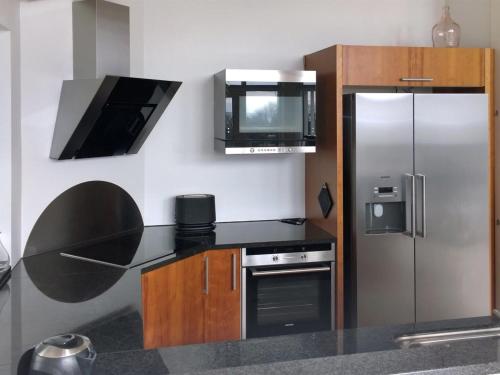 uma cozinha com um frigorífico de aço inoxidável e um micro-ondas em Holiday Home Vicente - 130m from the sea in Sealand by Interhome em Jægerspris