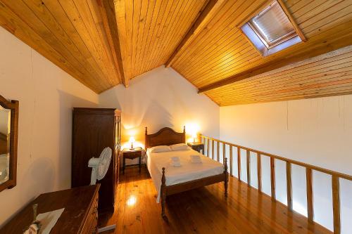 a bedroom with a bed and a wooden ceiling at Casa de Valdemar in Felgueiras