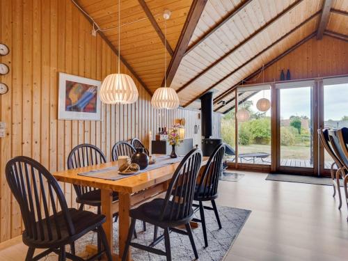 een eetkamer met een houten tafel en stoelen bij Holiday Home Ija - 200m from the sea in Sealand by Interhome in Føllenslev