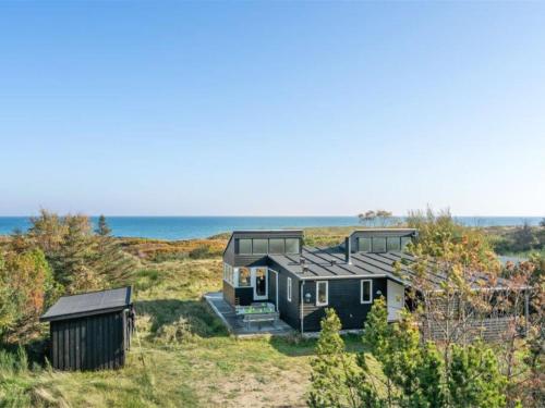 uma casa na praia com o oceano ao fundo em Holiday Home Helin - 100m from the sea in Sealand by Interhome em Yderby