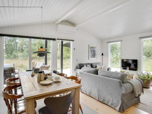 ein Wohnzimmer mit einem Sofa und einem Tisch in der Unterkunft Holiday Home Liselotte - 200m from the sea in Sealand by Interhome in Rørvig