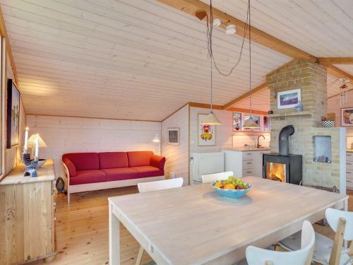 - un salon avec une table et un canapé rouge dans l'établissement Holiday Home Gundhild - all inclusive - 1-8km from the sea by Interhome, à Fårevejle