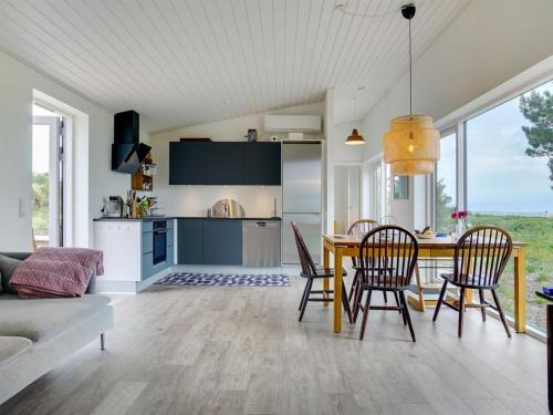 eine Küche und ein Esszimmer mit einem Tisch und Stühlen in der Unterkunft Holiday Home Gjorgje - 100m from the sea in Sealand by Interhome in Tjørneholm