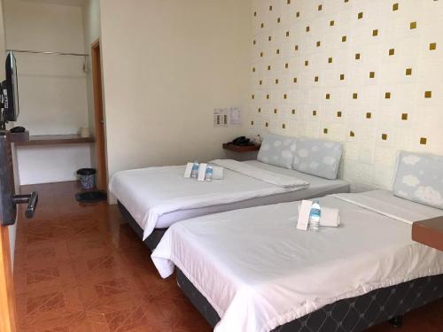 a room with two beds and a couch at I'm Inn Hotel Sorsogon near SM or Terminal in Sorsogon