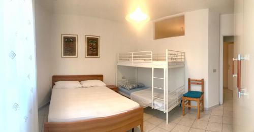 a bedroom with two beds and a bunk bed at Condominio Leda in Bibione