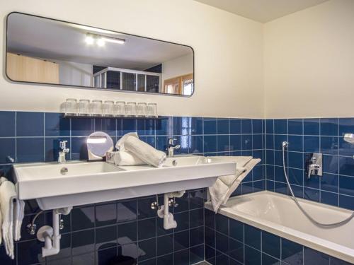 a bathroom with a sink and a tub and a mirror at Apartment Josefa am Buchhammerhof by Interhome in Kaunerberg