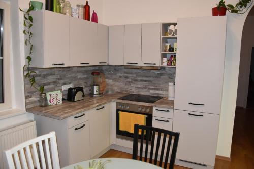 a kitchen with white cabinets and a stove at Wochenzimmer - Premium Apartments für Monteure, Event- und Projektteams in Sankt Peter-Freienstein