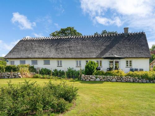 una casa blanca con techo gris y patio en Holiday Home Margareta - 250m to the inlet in Sealand by Interhome, en Præstø