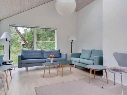 ein Wohnzimmer mit 2 blauen Sofas und Tischen in der Unterkunft Holiday Home Ella - 1-2km to the inlet in Sealand by Interhome in Rørvig