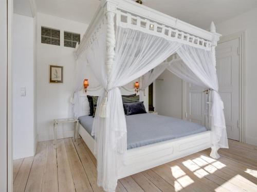 Una cama blanca con dosel en un dormitorio en Holiday Home Kadri in Sealand by Interhome, en Karise