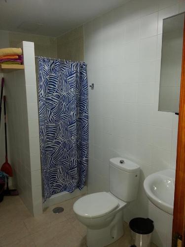 y baño con aseo y cortina de ducha. en Pozo Izquierdo Homelidays, en Pozo Izquierdo