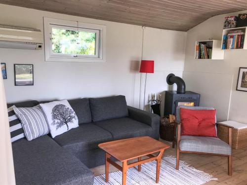 uma sala de estar com um sofá cinzento e uma cadeira em Holiday Home Vojo - 100m from the sea in Lolland- Falster and Mon by Interhome em Stubbekøbing