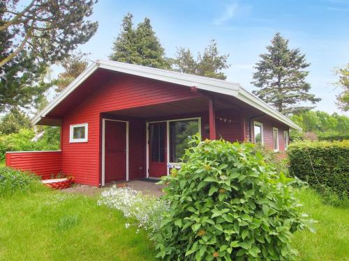 uma casa vermelha com uma porta vermelha num quintal em Holiday Home Thing - 200m from the sea in Lolland- Falster and Mon by Interhome em Askeby