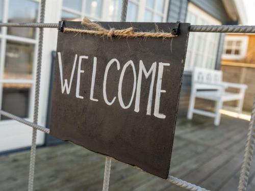 a sign that says welcome on a porch at Holiday Home Sazur - 75m from the sea in Funen by Interhome in Mesinge