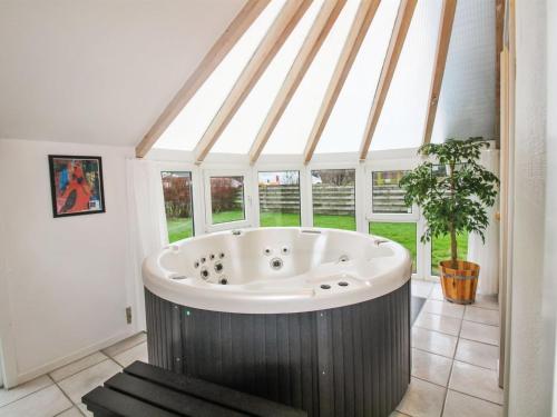 uma grande casa de banho com banheira num quarto com janelas em Holiday Home Elbert - 100m from the sea in Funen by Interhome em Otterup