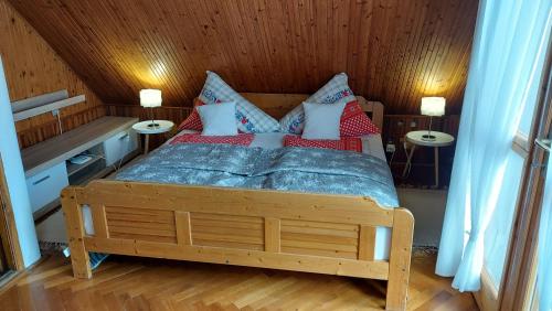 a bedroom with a bed with red pillows at Titi Boutique Apartmanok in Bükfürdő