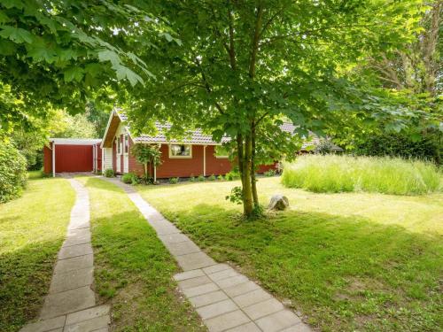 a house with a tree in the yard at Holiday Home Maard - 325m from the sea by Interhome in Martofte