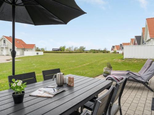 uma mesa de madeira com um guarda-chuva num pátio em Holiday Home Askan - 200m from the sea in Funen by Interhome em Bro