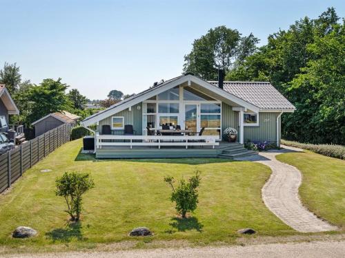 ein Haus mit einer großen umlaufenden Veranda in der Unterkunft Holiday Home Diertje - 10m from the sea in Funen by Interhome in Otterup