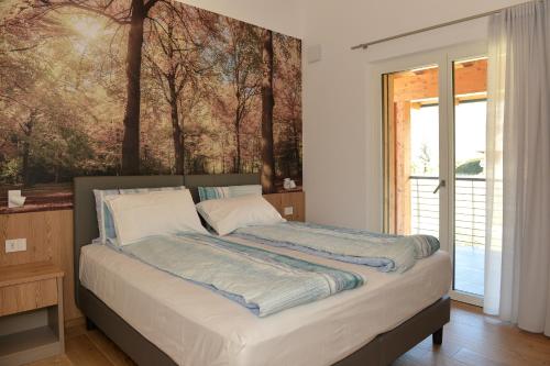 1 dormitorio con 1 cama con una pintura en la pared en Bed and Breakfast NAVIS en Nave San Rocco