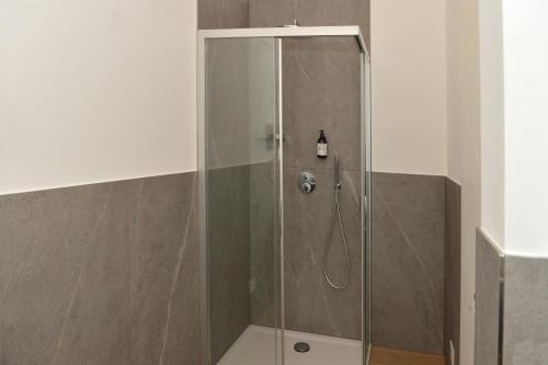 La salle de bains est pourvue d'une douche avec une porte en verre. dans l'établissement Bed and Breakfast NAVIS, à Nave San Rocco