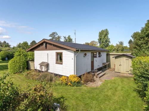 a small white house with a yard at Holiday Home Henrich - 300m from the sea in Lolland- Falster and Mon by Interhome in Vesterby