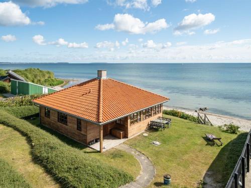 Ullerslev的住宿－Holiday Home Botmar - 10m from the sea in Funen by Interhome，海滩上一座带橙色屋顶的房子